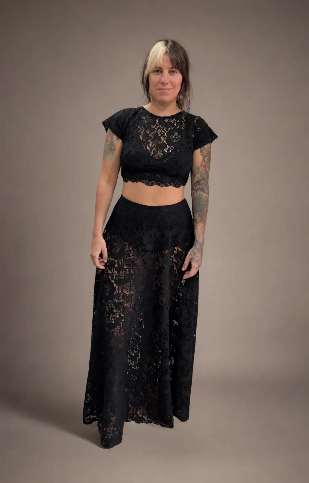 Conjunto de dos piezas en encaje negro, top y falda larga, lucido por una modelo en estudio.