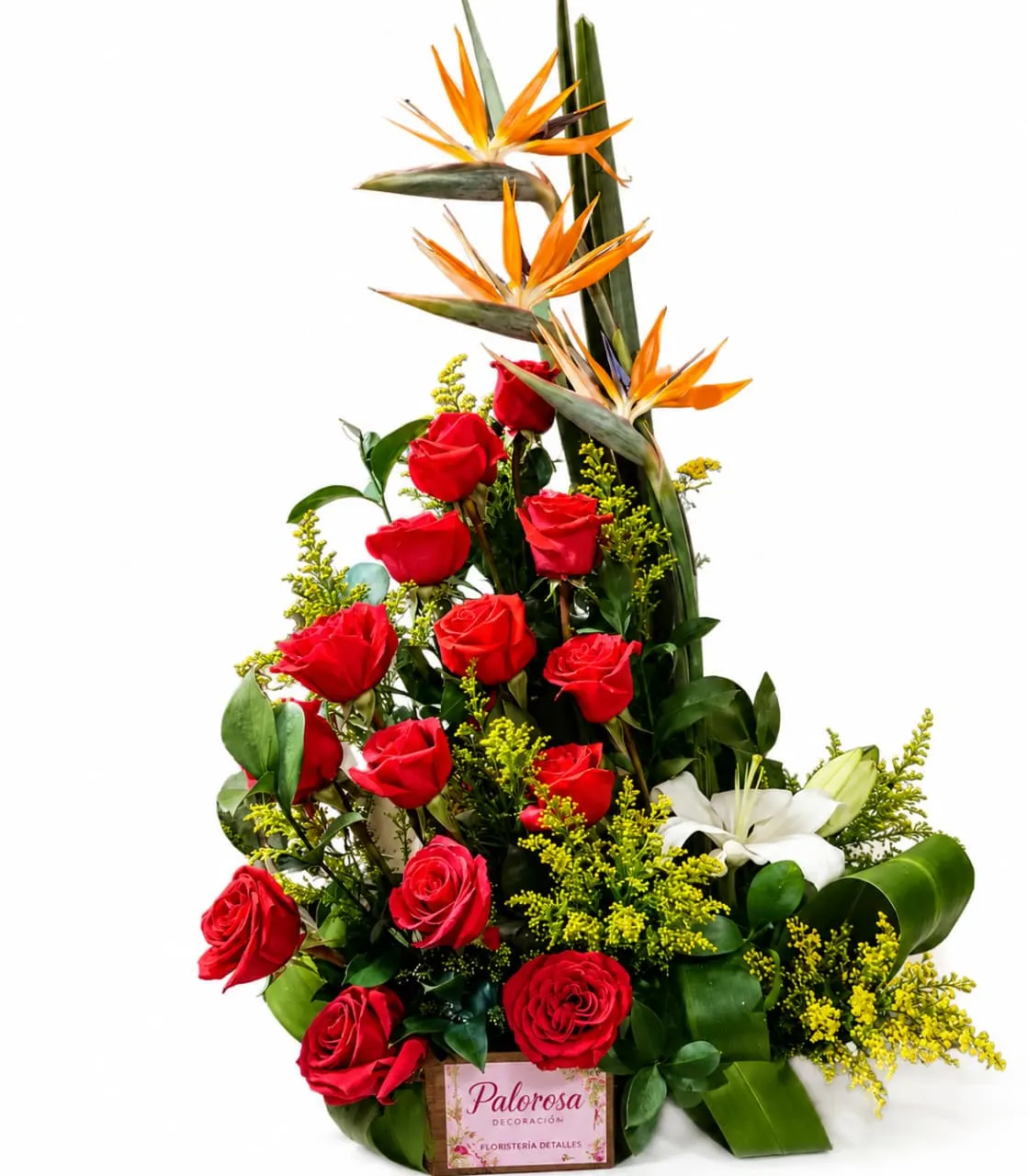 Arreglo floral de rosas rojas, lirio blanco y aves del paraíso sobre base de hojas, con sello de Palorosa Decoración.